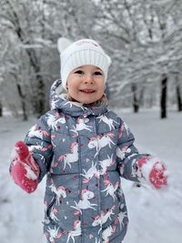 Portrait of smiling girl standing on snow