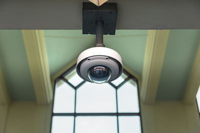 Low angle view of cctv camera hanging on ceiling 