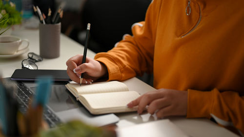 Midsection of man working on table