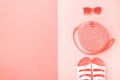 Close-up of heart shape on pink shoes against wall