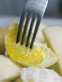 Close up view of fork picking up slice of orange