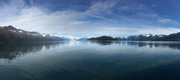 Scenic view of lake by mountains against sky