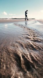 Man standing on beach against sky