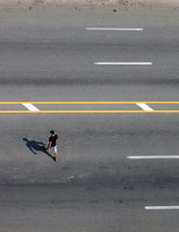 High angle view of man crossing a road