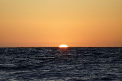 Scenic view of sea against orange sky