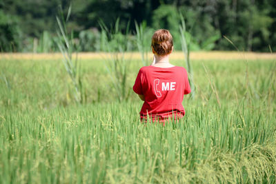 Rear view of boy on field