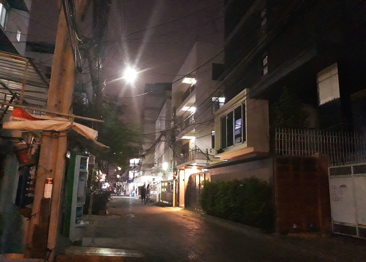 STREET AMIDST BUILDINGS AT NIGHT