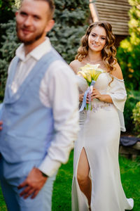 Portrait of newlywed couple against trees