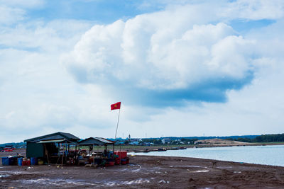 Flag on beach against sky