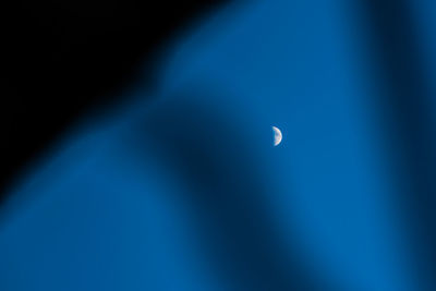 Low angle view of moon against blue sky
