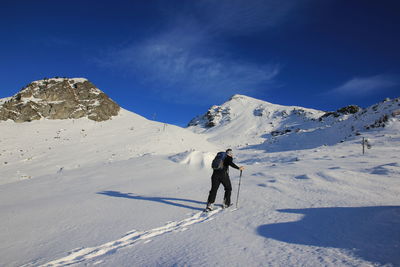 Rear view of man walking on mountain during winter