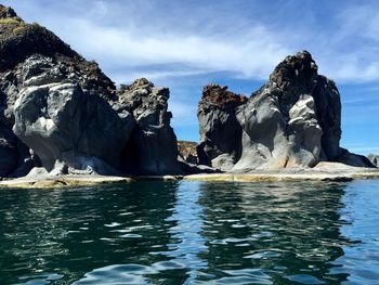 Rocks in sea against sky