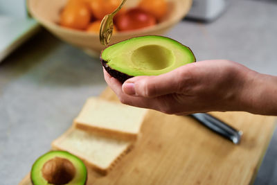 Ripe avocado in woman hands, healthy breakfast