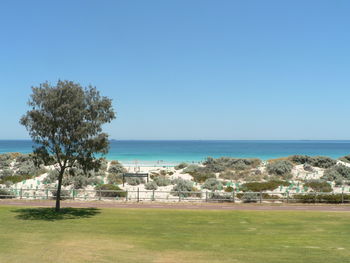 Scenic view of calm beach against clear sky