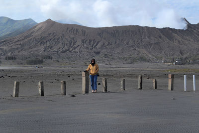 Full length rear view of man standing on arid landscape