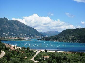 Scenic view of bay and mountains against sky