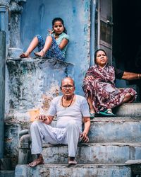 Portrait of family sitting outside house