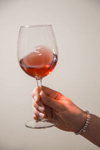 Midsection of woman holding wineglass