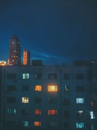 Low angle view of illuminated buildings against sky at night