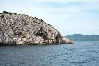 Rock formations by sea against sky