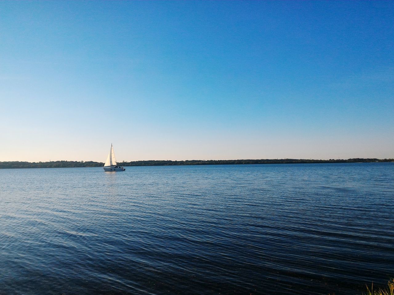 water, clear sky, copy space, sea, tranquil scene, tranquility, waterfront, blue, scenics, nautical vessel, transportation, rippled, beauty in nature, nature, mode of transport, boat, horizon over water, idyllic, seascape, sailboat