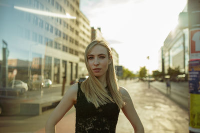 Portrait of young woman standing in city