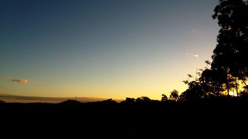 Silhouette landscape against clear sky during sunset