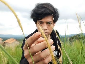 Portrait of young man looking away on field