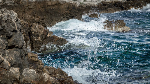 Sea waves splashing on rocks in salento during winter