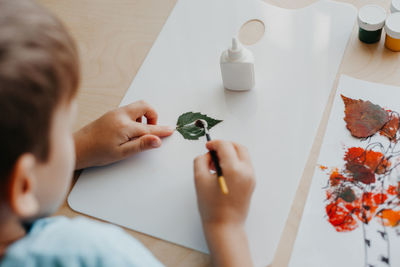 Cropped hands of woman using mobile phone on table