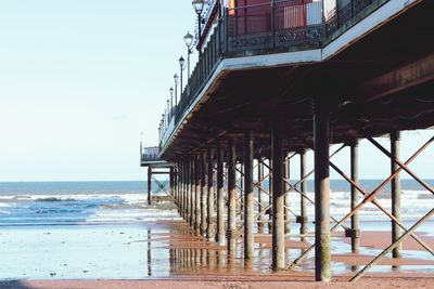 View of pier on beach against clear sky