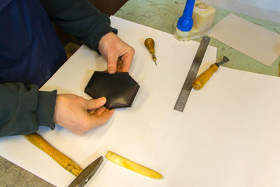 Midsection of shoemaker working in workshop