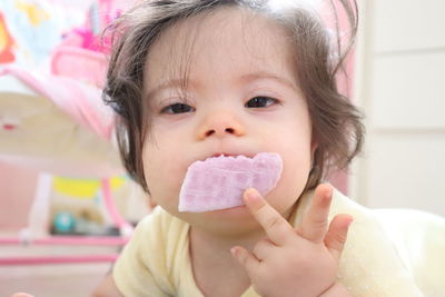 Close-up portrait of cute baby girl with food on mouth at home