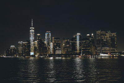 Illuminated buildings in city against sky at night