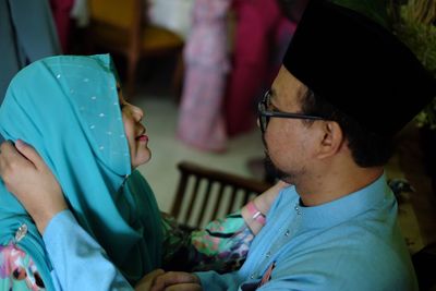 Close-up of couple in traditional clothing embracing indoors