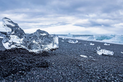 Close-up of beautiful ice crystal on black sand shore of diamond beach