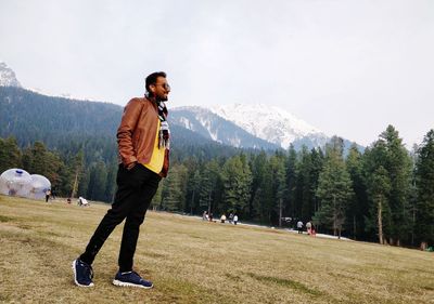 Man walking on field against sky