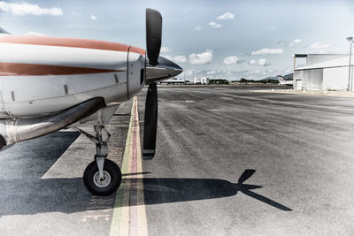 Airplane on airport runway against sky