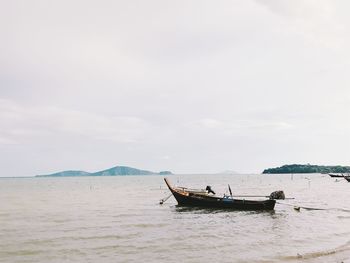 Fishing boats in sea against sky