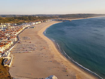 High angle view of beach by city against sky