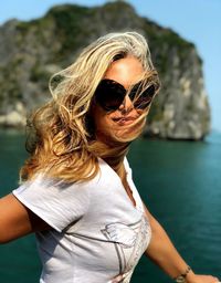 Portrait of woman wearing sunglasses against sea