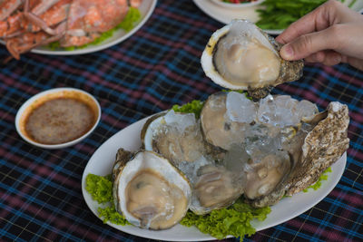 High angle view of hand holding food on table