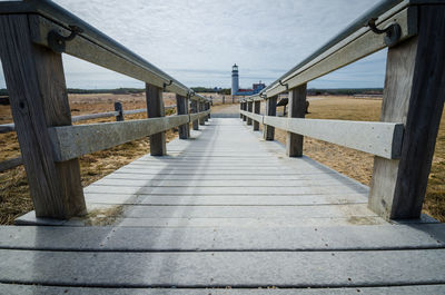 Empty pier over sea against sky