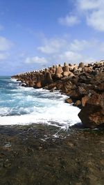 Rocks on beach against sky