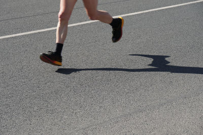 Low section of woman running on road