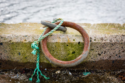 Close-up of rusty circle at harbor