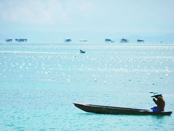 Man on boat in sea against sky