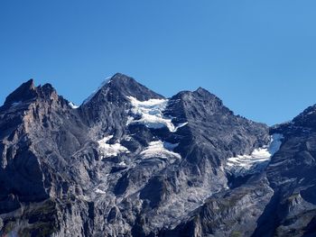 Scenic view of snowcapped mountains against clear blue sky