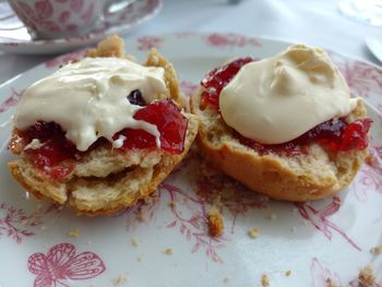 High angle view of desserts with jam and cream in plate 