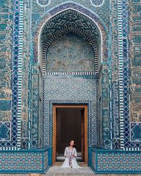 Full length rear view of woman standing against building